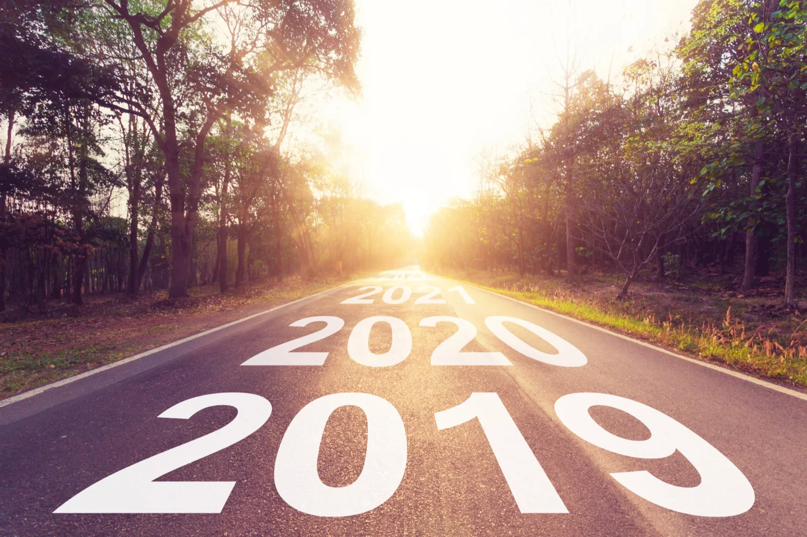 Gün batımına uzanan bir yolun üzerine yazılmış 2019 ve 2020 yılları